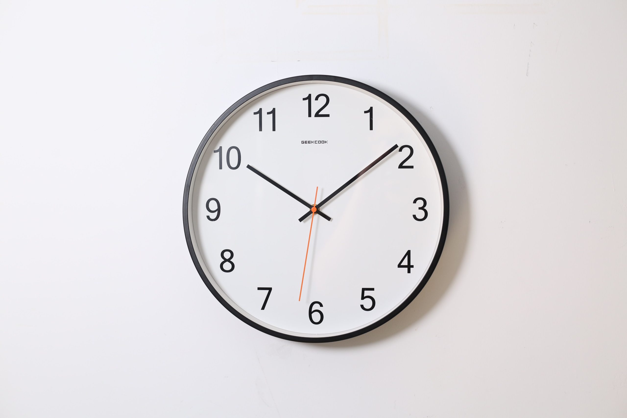 A clock on the wall representing a time-clause offer in real estate, when choosing to sell or buy a home first.